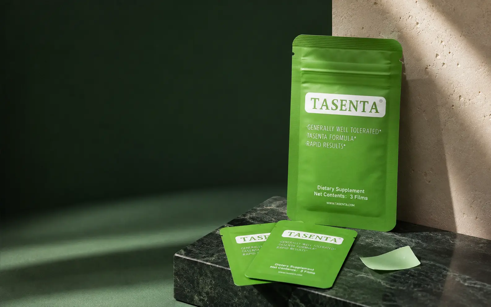TASENTA oral film pouch, individual packets and film presented on dark green stone